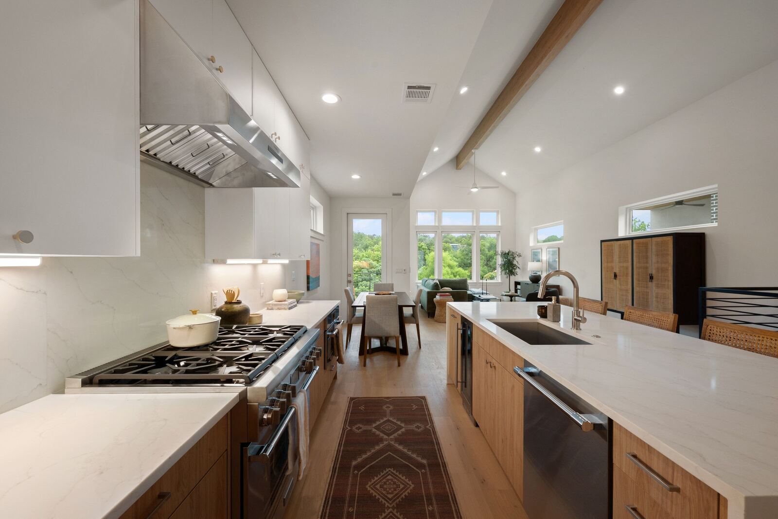 Open kitchen with waterfall island, Thermador range and vaulted ceiling