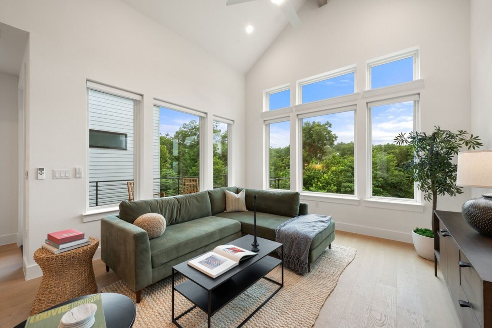 Living room with vaulted ceiling, oversized windows and greenbelt views